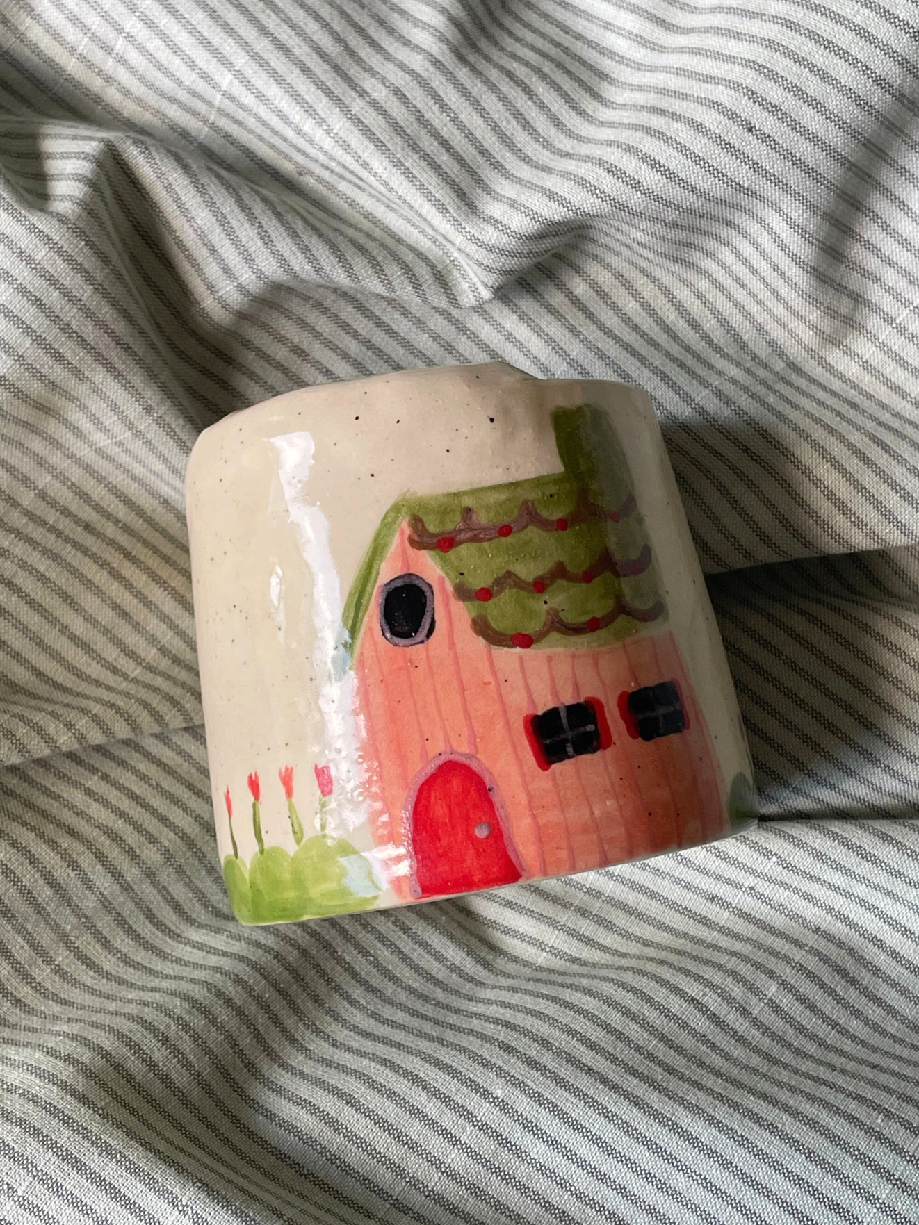 Ceramic house-shaped travel mug with a whimsical drawing